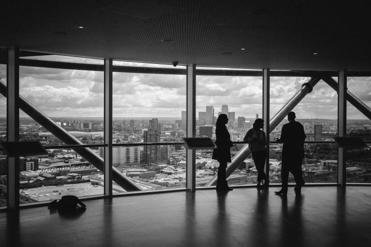 People in a high rise looking at a view of a skyline.