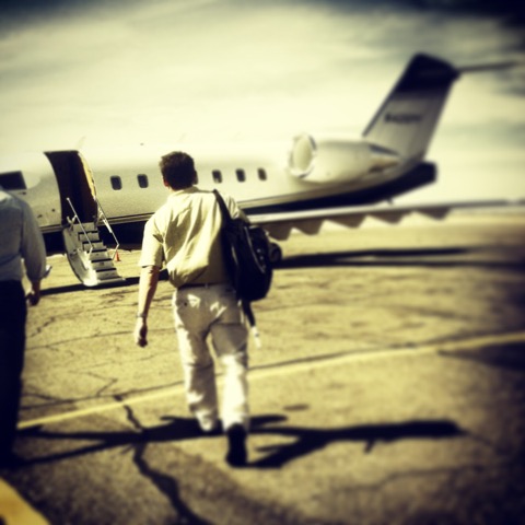 Man being escorted to his private plane by his body guard